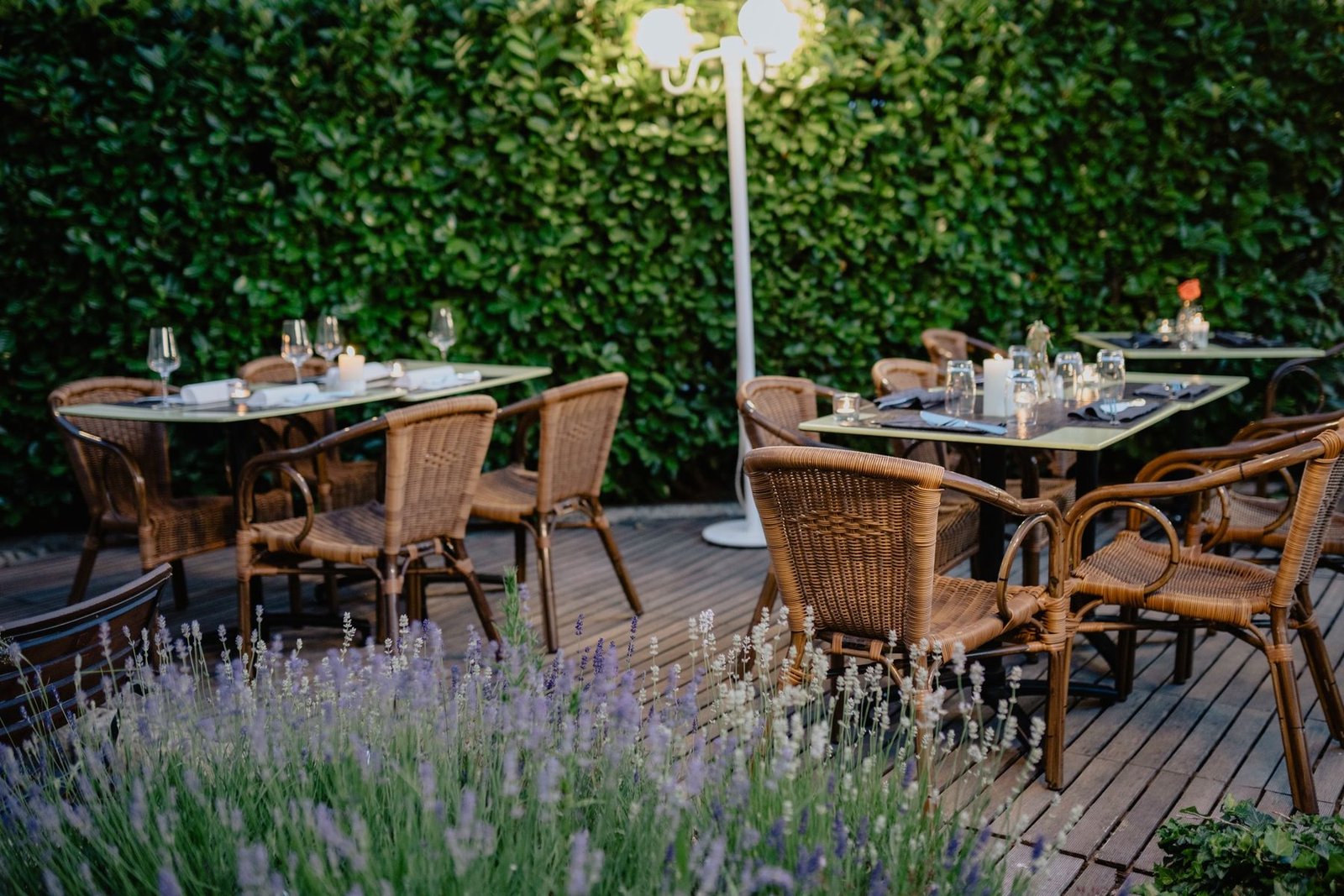 Terraza jardín con mesas preparadas al atardecer